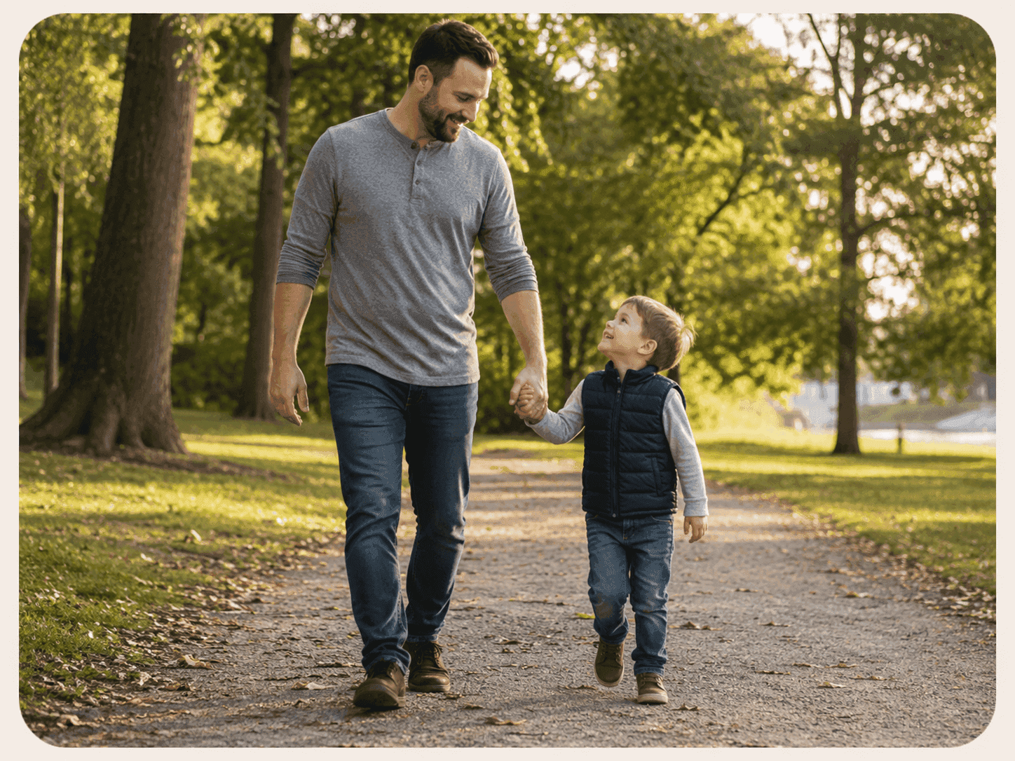 A father and his young son walking together on a tree-lined path